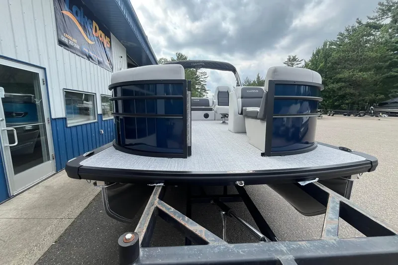 Slide: The Image of 2026 Harris Cruiser 210 pontoon boat at a dealership, showcasing modern design and spacious deck. - 5