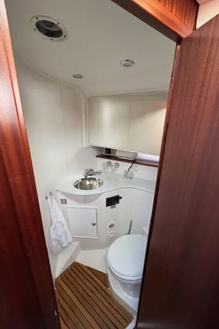 Slide: The Image of Das Bild zeigt ein modernes Badezimmer auf einem Boot mit Holzboden und weißen Wänden. - 16