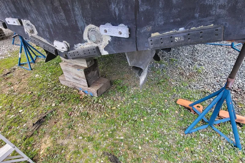 Slide: The Image of 2008 Marquis 40 SC boat hull on stands, showing propeller and rudder. - 11