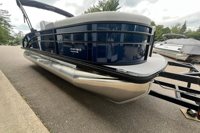 Slide: The Image of 2026 Harris Cruiser 210 pontoon boat on trailer, parked outdoors. - 5