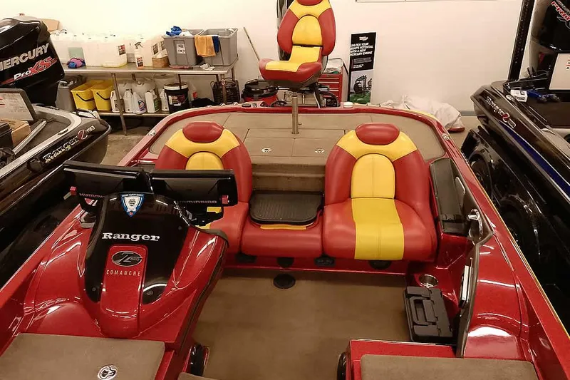 Slide: The Image of 2008 Ranger Z520 Comanche boat with red and yellow seats in a garage setting. - 31