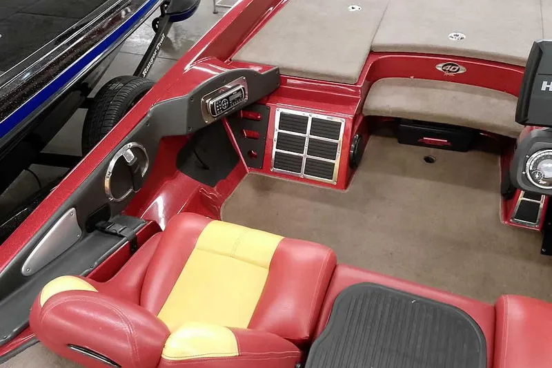 Slide: The Image of 2008 Ranger Z520 Comanche boat interior with red and yellow seating, dashboard, and carpeted flooring. - 33