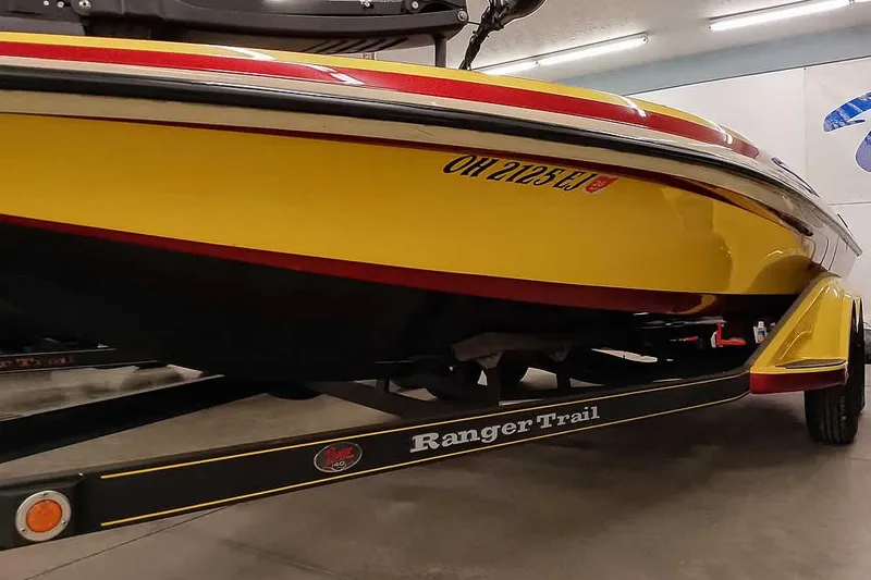 Slide: The Image of 2008 Ranger Z520 Comanche boat on trailer, yellow and red design, indoor setting. - 7