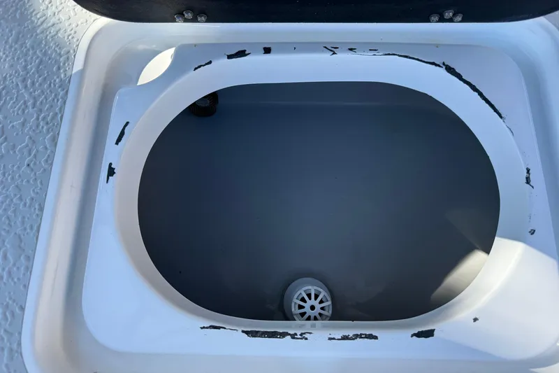 Slide: The Image of Open storage compartment in 2018 SCB Recon boat with visible wear. - 32