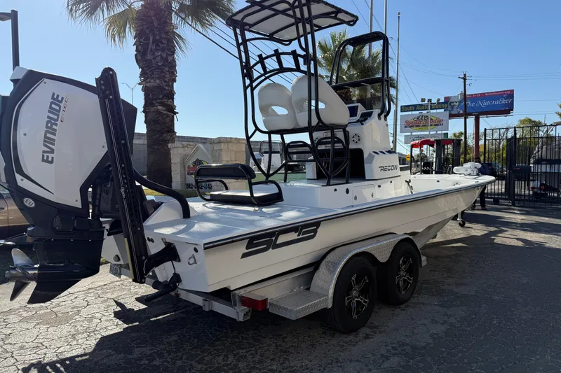 Slide: The Image of 2018 SCB Recon boat with Evinrude engine on trailer, parked outdoors. - 48