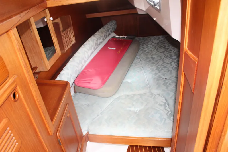 Slide: The Image of 1998 Nauticat 32 Pilothouse cabin interior with wooden finish and cozy bedding. - 13