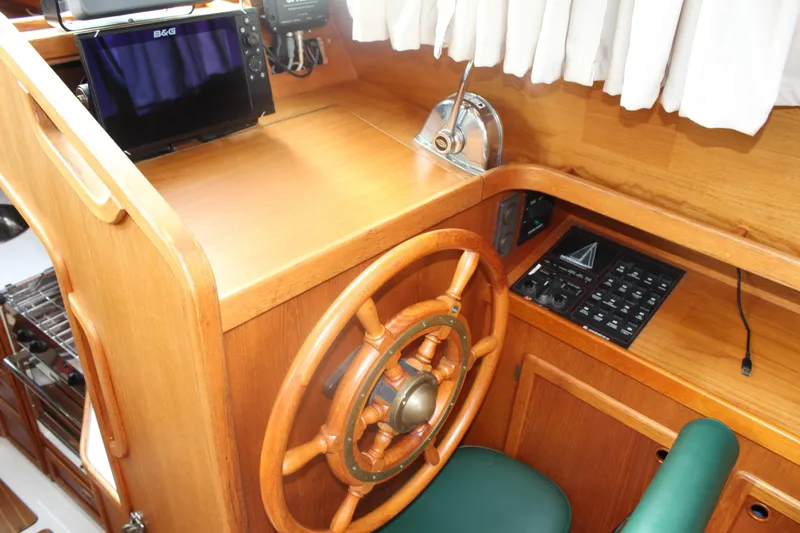 Slide: The Image of Pilothouse interior of 1998 Nauticat 32, featuring wooden helm and navigation equipment. - 14