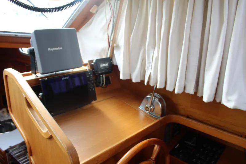 Slide: The Image of Pilothouse interior of 1998 Nauticat 32, featuring navigation equipment and wooden helm. - 15