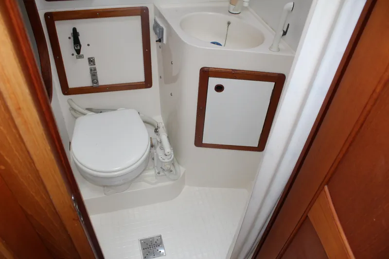 Slide: The Image of 1998 Nauticat 32 Pilothouse bathroom with toilet, sink, and wooden cabinetry. - 24