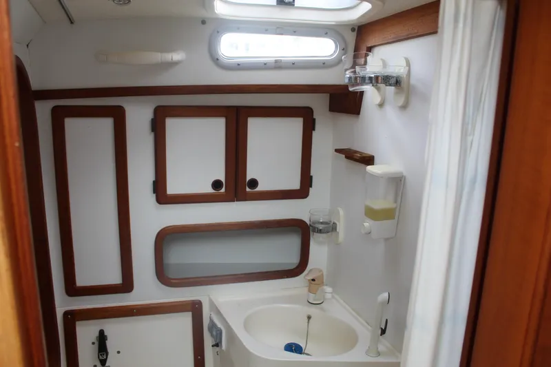 Slide: The Image of Nauticat 32 Pilothouse 1998 bathroom with wooden cabinets and sink. - 25