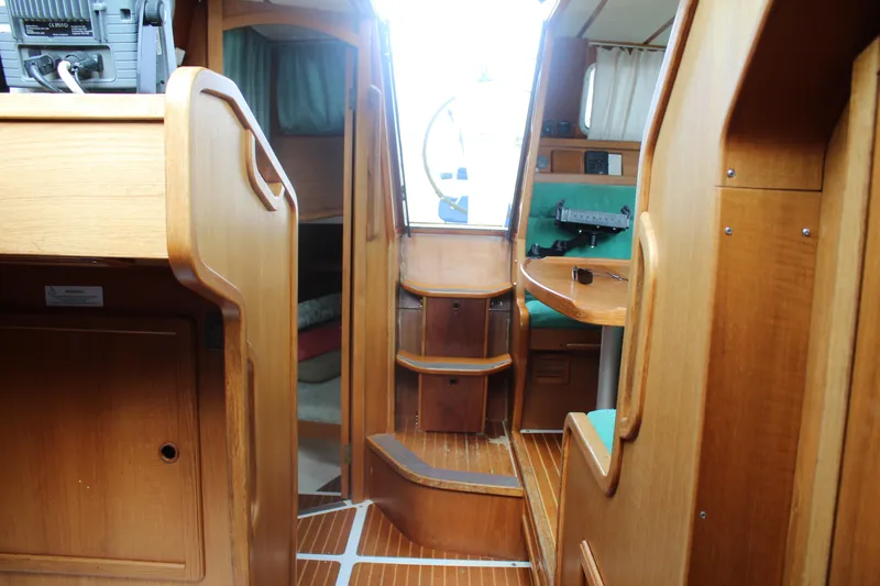 Slide: The Image of Interior of 1998 Nauticat 32 Pilothouse, featuring wooden cabinetry and seating area. - 26