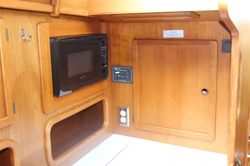 Slide: The Image of Interior of 1998 Nauticat 32 Pilothouse with microwave and wooden cabinetry. - 28