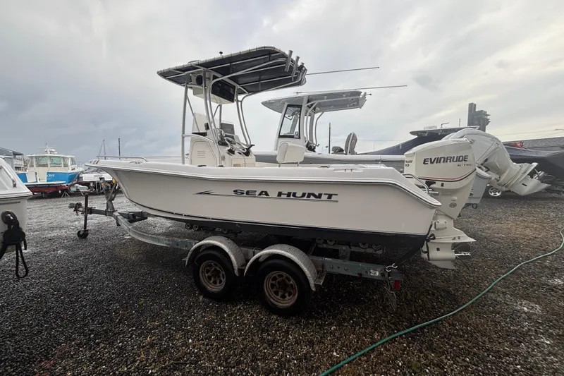The Image of 2006 Sea Hunt Triton 207 boat on trailer, featuring Evinrude outboard motor. - 0