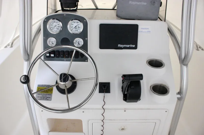 Slide: The Image of 2006 Sea Hunt Triton 207 boat console with steering wheel and Raymarine equipment. - 2