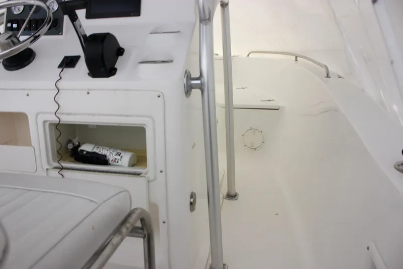 Slide: The Image of 2006 Sea Hunt Triton 207 boat interior with steering wheel and storage compartment. - 20