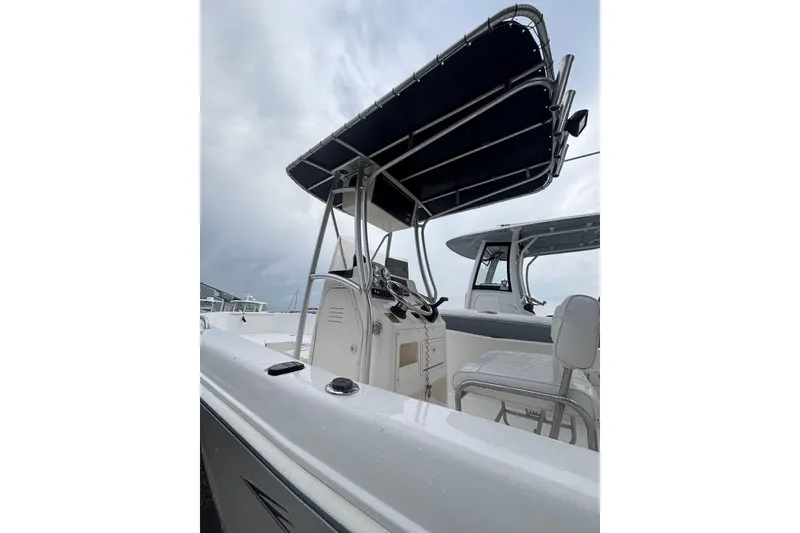 Slide: The Image of 2006 Sea Hunt Triton 207 boat with T-top and console, viewed from the side. - 22