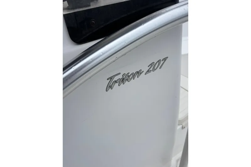 Slide: The Image of Close-up of 2006 Sea Hunt Triton 207 boat model name on white surface. - 27