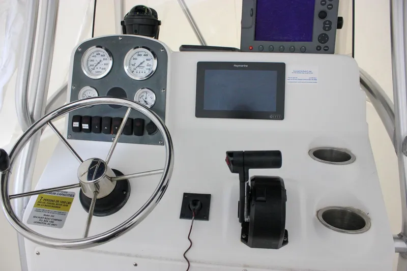 Slide: The Image of Control panel of a 2006 Sea Hunt Triton 207 boat with steering wheel and gauges. - 9