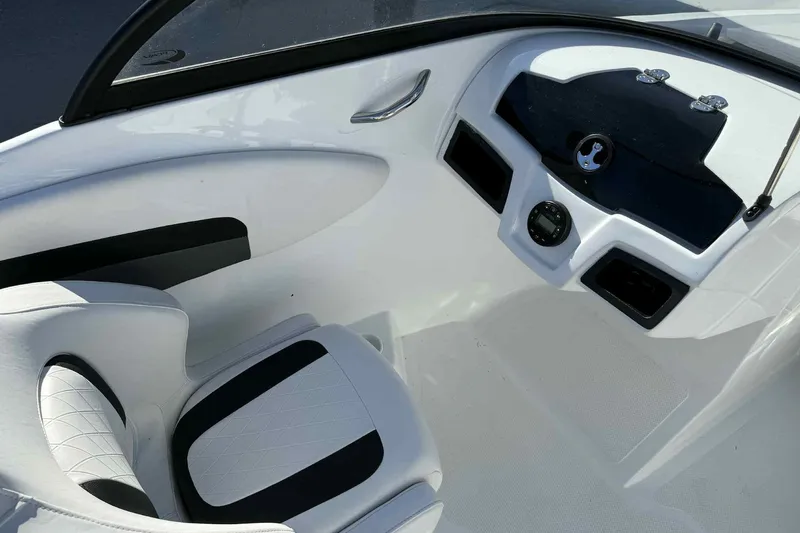 Slide: The Image of Interior of 2021 Tahoe 550 TS boat, featuring sleek white and black seating and dashboard. - 10