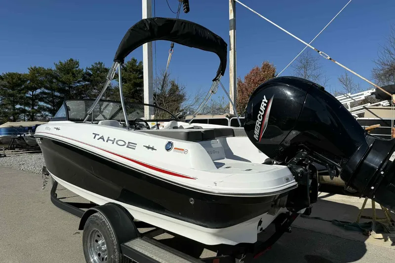 Slide: The Image of 2021 Tahoe 550 TS boat with Mercury engine on trailer, outdoors. - 2