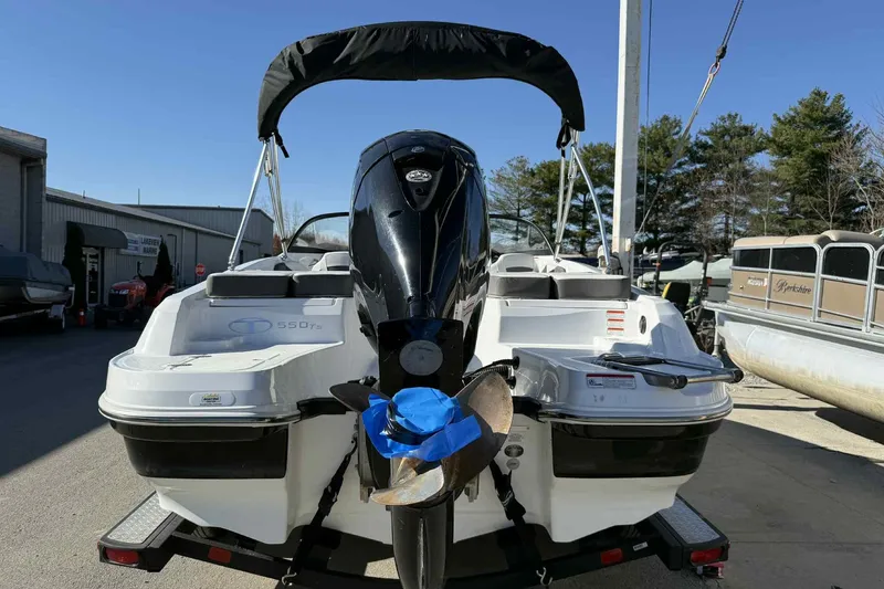 Slide: The Image of 2021 Tahoe 550 TS boat with outboard motor, parked on a trailer. - 3