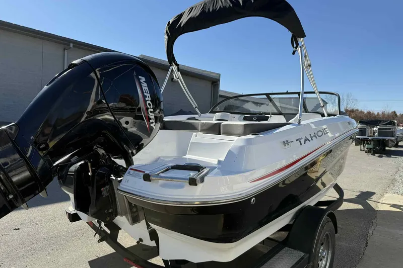 Slide: The Image of 2021 Tahoe 550 TS boat with Mercury engine, parked outdoors on a sunny day. - 4