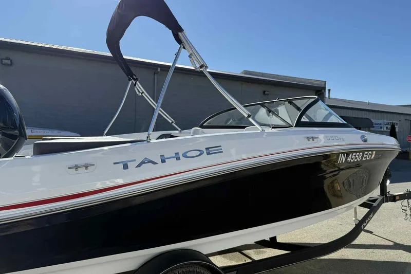 Slide: The Image of 2021 Tahoe 550 TS boat on trailer, black and white design, parked outdoors. - 5