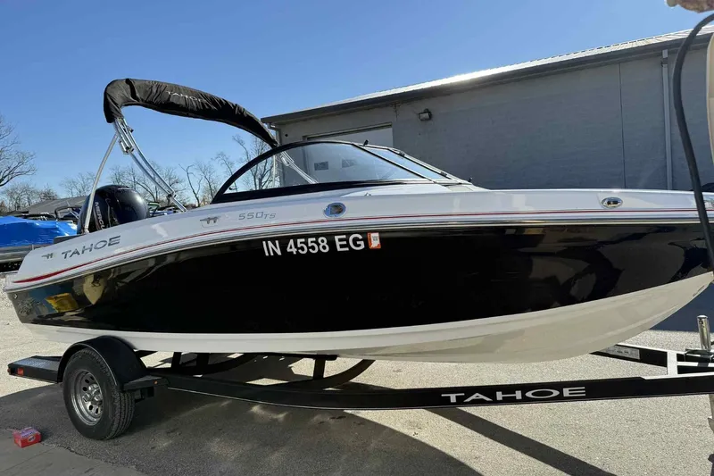 Slide: The Image of 2021 Tahoe 550 TS boat on trailer, black and white design, parked outdoors. - 6