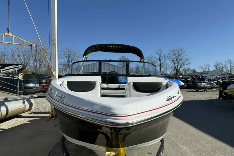 Slide: The Image of 2021 Tahoe 550 TS boat in a marina, clear sky, surrounded by other boats. - 7