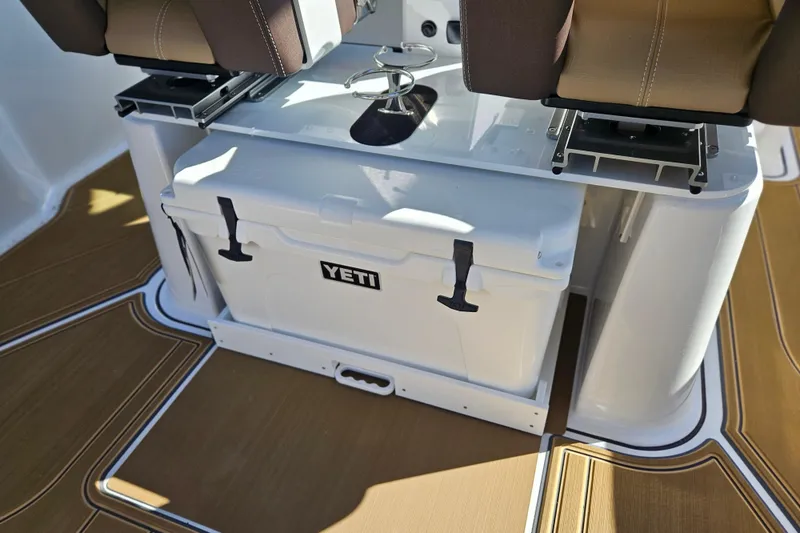 Slide: The Image of 2026 Monterey Elite 27 OB boat interior with Yeti cooler and brown seating. - 16