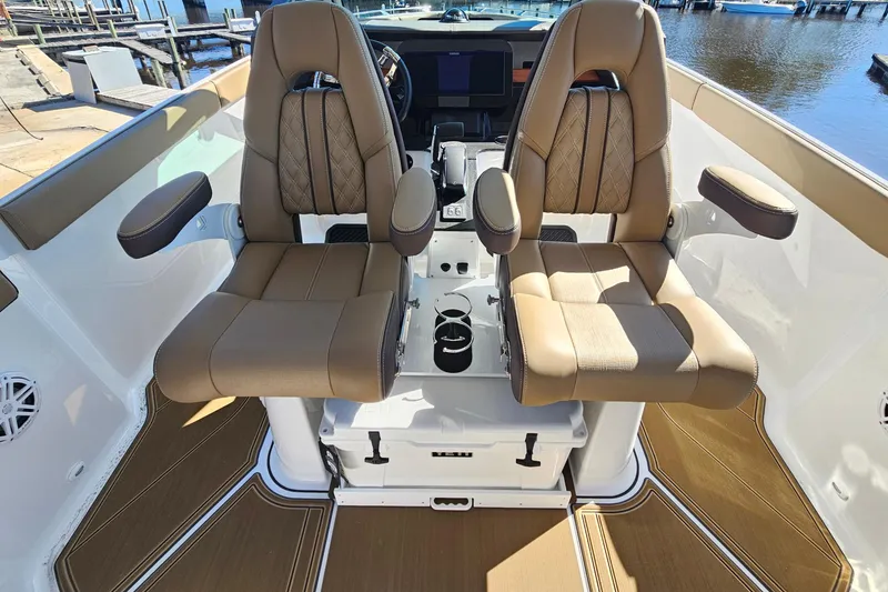 Slide: The Image of Luxury seating on 2026 Monterey Elite 27 OB boat, featuring tan leather and armrests. - 30