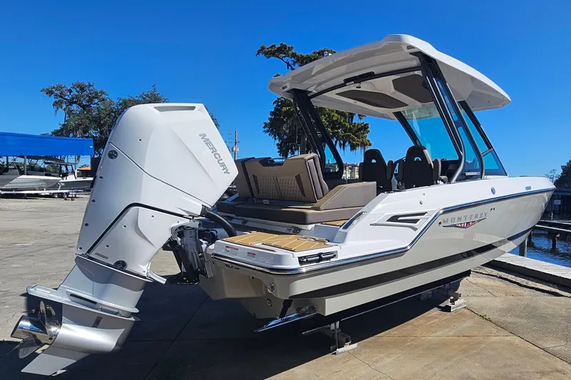 Slide: The Image of 2026 Monterey Elite 27 OB boat with Mercury outboard engine, docked under clear blue sky. - 5