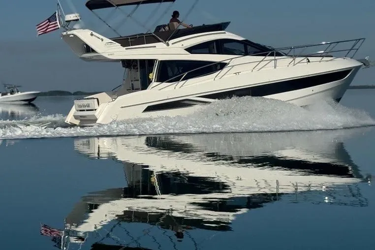 Slide: The Image of 2017 Galeon 380 Fly yacht cruising on calm water with American flag. - 1