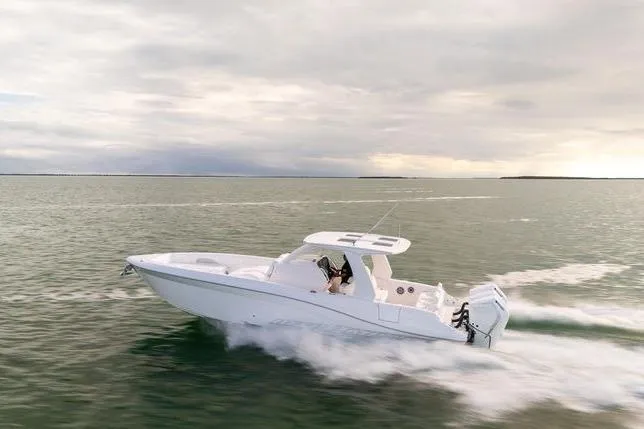 Slide: The Image of 2025 Deep Impact 369 Sport boat cruising on open water under cloudy skies. - 13