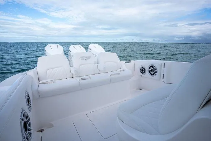 Slide: The Image of 2025 Deep Impact 369 Sport boat interior with white seating, ocean view, and speaker system. - 4