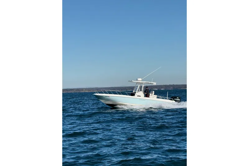 The Image of 2014 Boston Whaler 270 Dauntless cruising on open water under clear blue skies. - 0