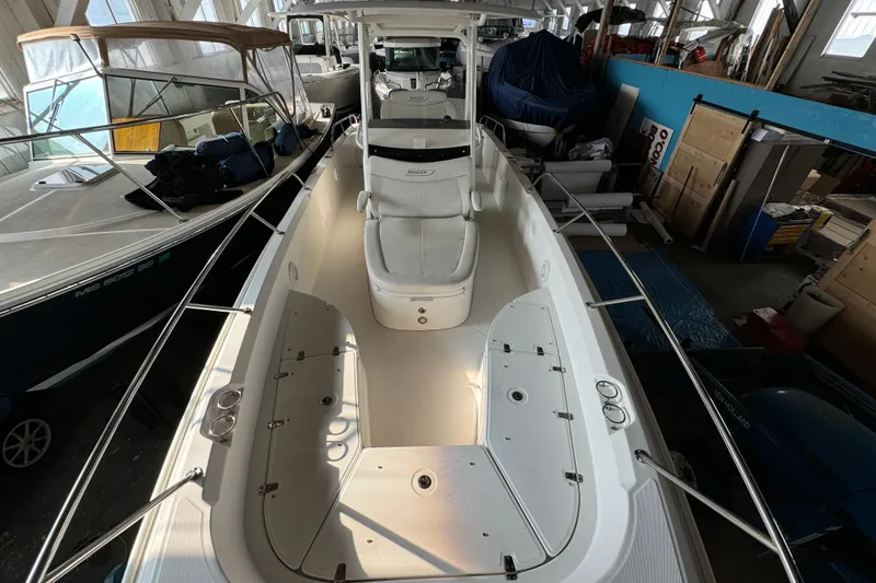 Slide: The Image of 2014 Boston Whaler 270 Dauntless boat interior in storage, showcasing seating and deck layout. - 11