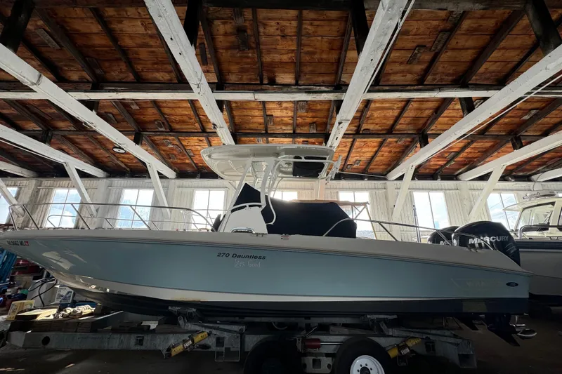Slide: The Image of 2014 Boston Whaler 270 Dauntless boat in a wooden boathouse, side view. - 3