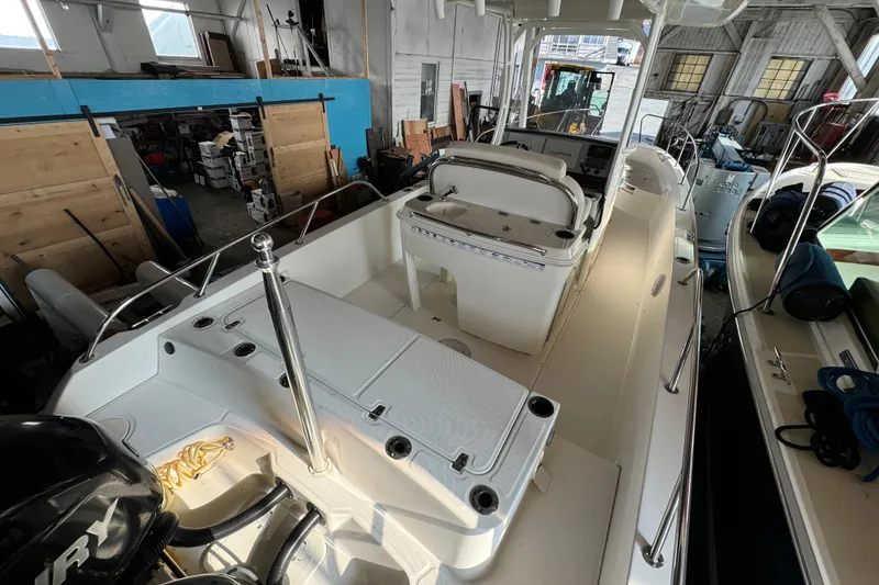 Slide: The Image of 2014 Boston Whaler 270 Dauntless boat interior in storage, showcasing seating and controls. - 4