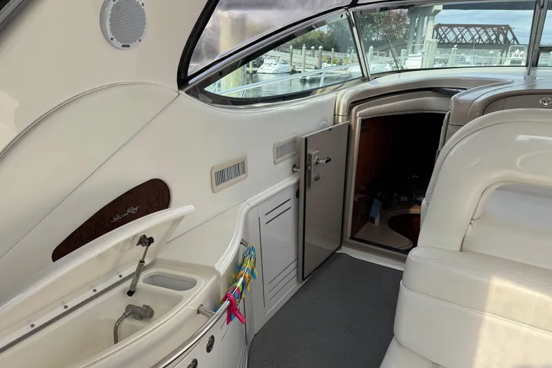 Slide: The Image of Interior view of a 2001 Sea Ray 510 Sundancer yacht, featuring sleek white seating and cabinetry. - 15