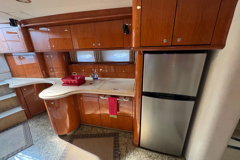 Slide: The Image of Luxurious kitchen interior of 2001 Sea Ray 510 Sundancer yacht with wood cabinetry and stainless steel fridge. - 16