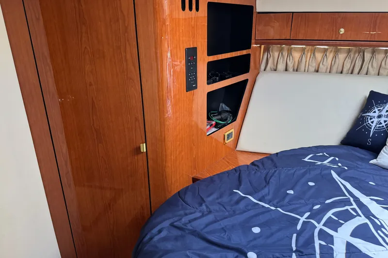 Slide: The Image of Interior cabin of 2001 Sea Ray 510 Sundancer with wood paneling and nautical-themed bedding. - 20