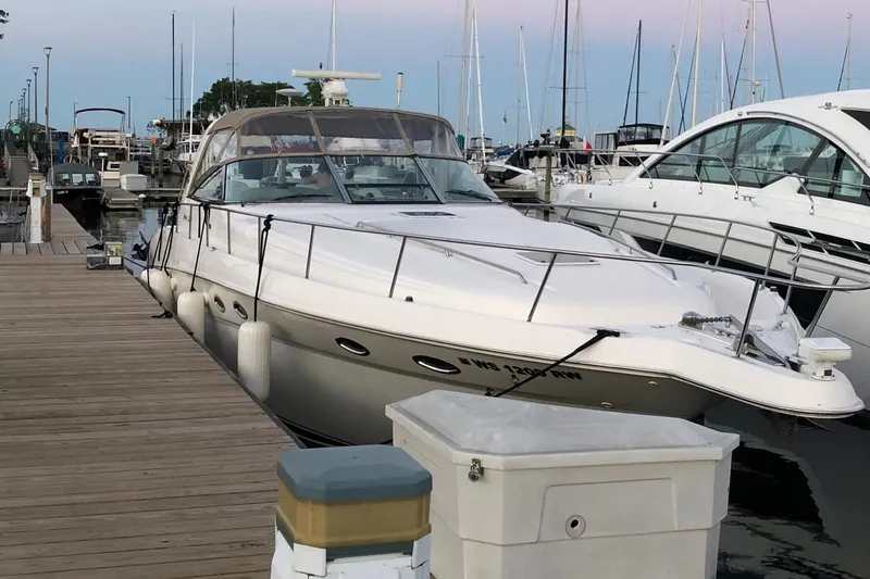 Slide: The Image of 2000 Sea Ray 460 Sundancer yacht docked at marina, surrounded by other boats. - 2
