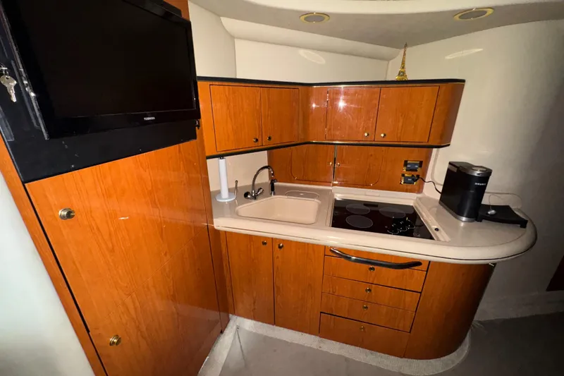 Slide: The Image of 2000 Sea Ray 460 Sundancer yacht kitchen with wood cabinetry and modern appliances. - 23
