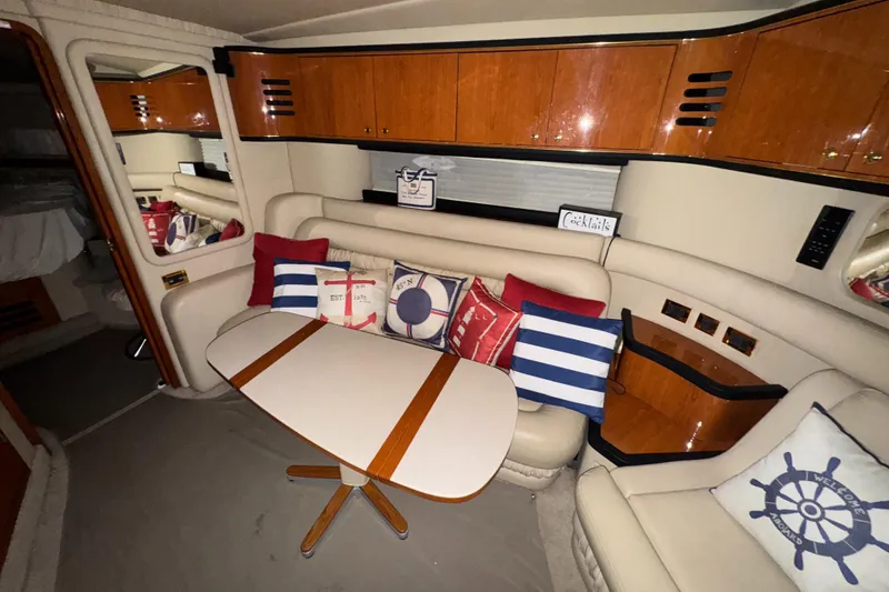 Slide: The Image of Interior of 2000 Sea Ray 460 Sundancer with nautical-themed cushions and wooden cabinetry. - 24