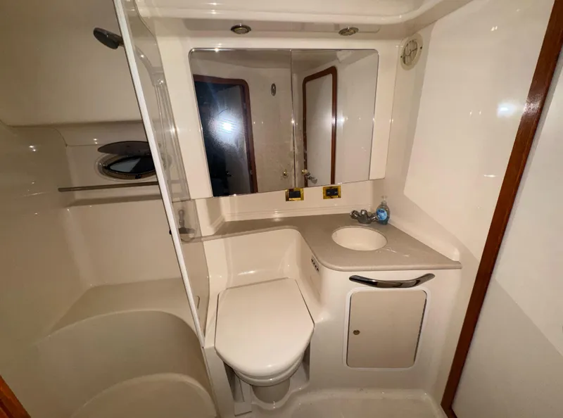 Slide: The Image of Bathroom interior of 2000 Sea Ray 460 Sundancer yacht, featuring sink, toilet, and shower. - 27
