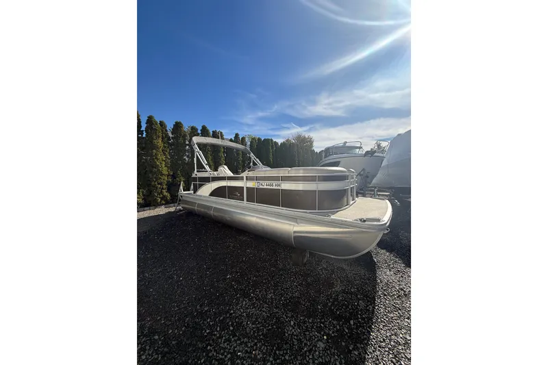 The Image of 2016 Bennington SX22 pontoon boat parked on gravel under a clear blue sky. - 0