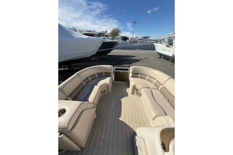 Slide: The Image of 2016 Bennington SX22 pontoon boat with beige seating, docked among other boats. - 11