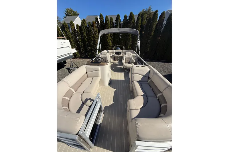 Slide: The Image of 2016 Bennington SX22 pontoon boat with spacious seating and canopy, parked outdoors. - 16