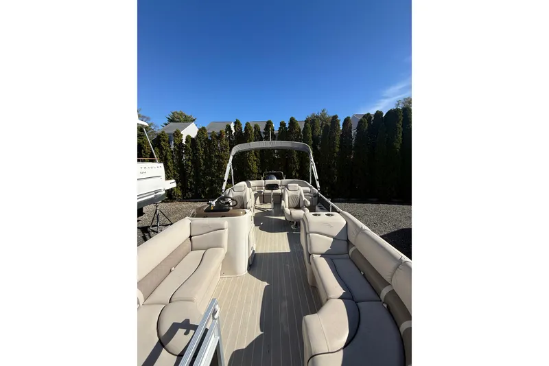 Slide: The Image of 2016 Bennington SX22 pontoon boat with beige seating and canopy, parked outdoors. - 17